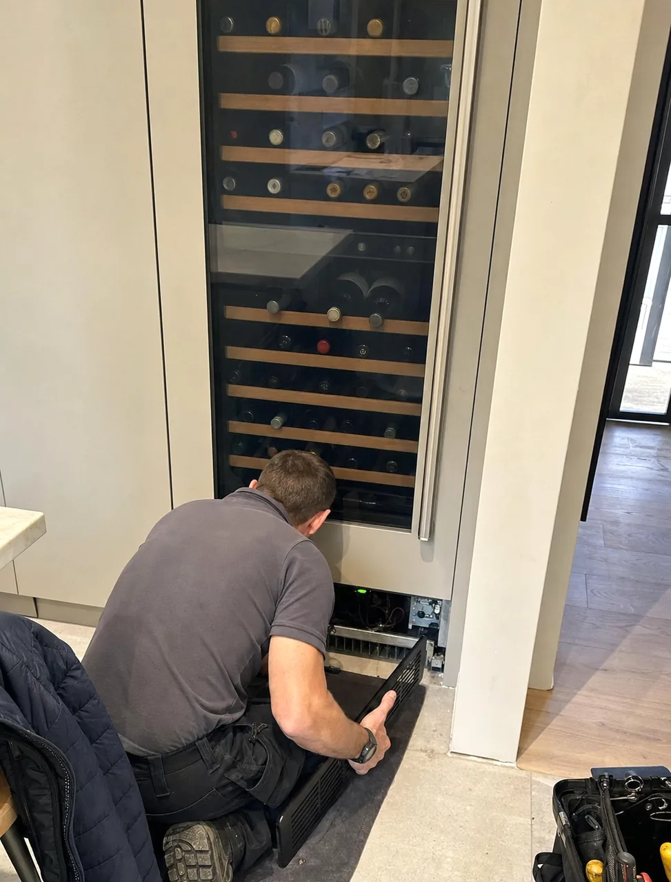 A wine column with a technician at its base, mirrored so the glazed wall falls on the right of the frame.